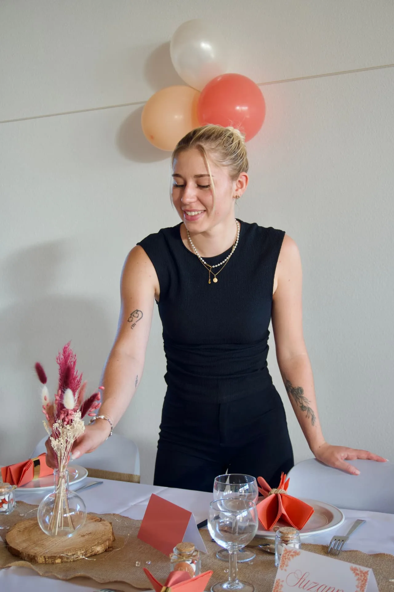 Justine dressant une table décorée pour un événement en Franche-Comté
